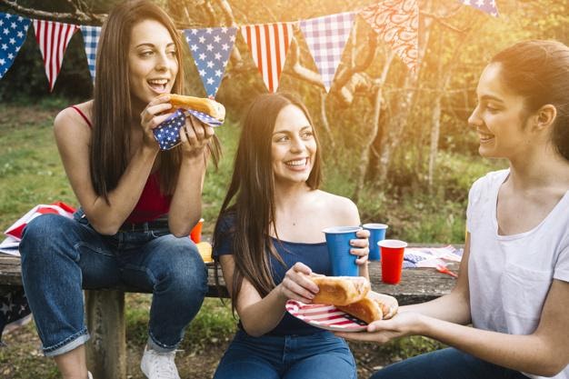 Young women eating hot-dogs | Free Photo